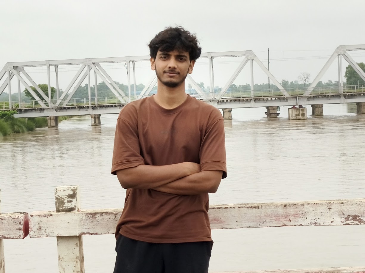 Anubhav Mishra standing by a riverside bridge